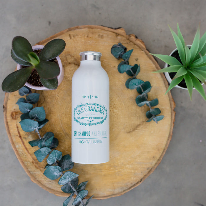 All natural, powder Dry Shampoo for women. In a white sprinkle bottle.